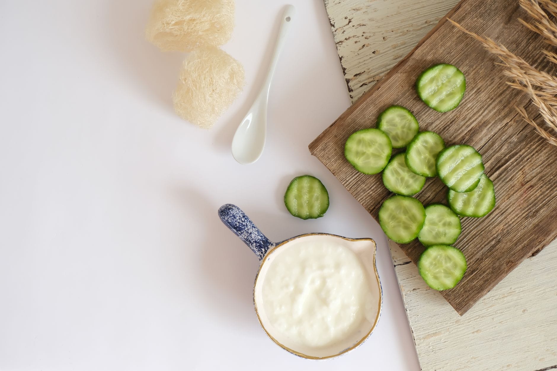 Loofah, sliced cucumber, and a bowl of yogurt for skin care