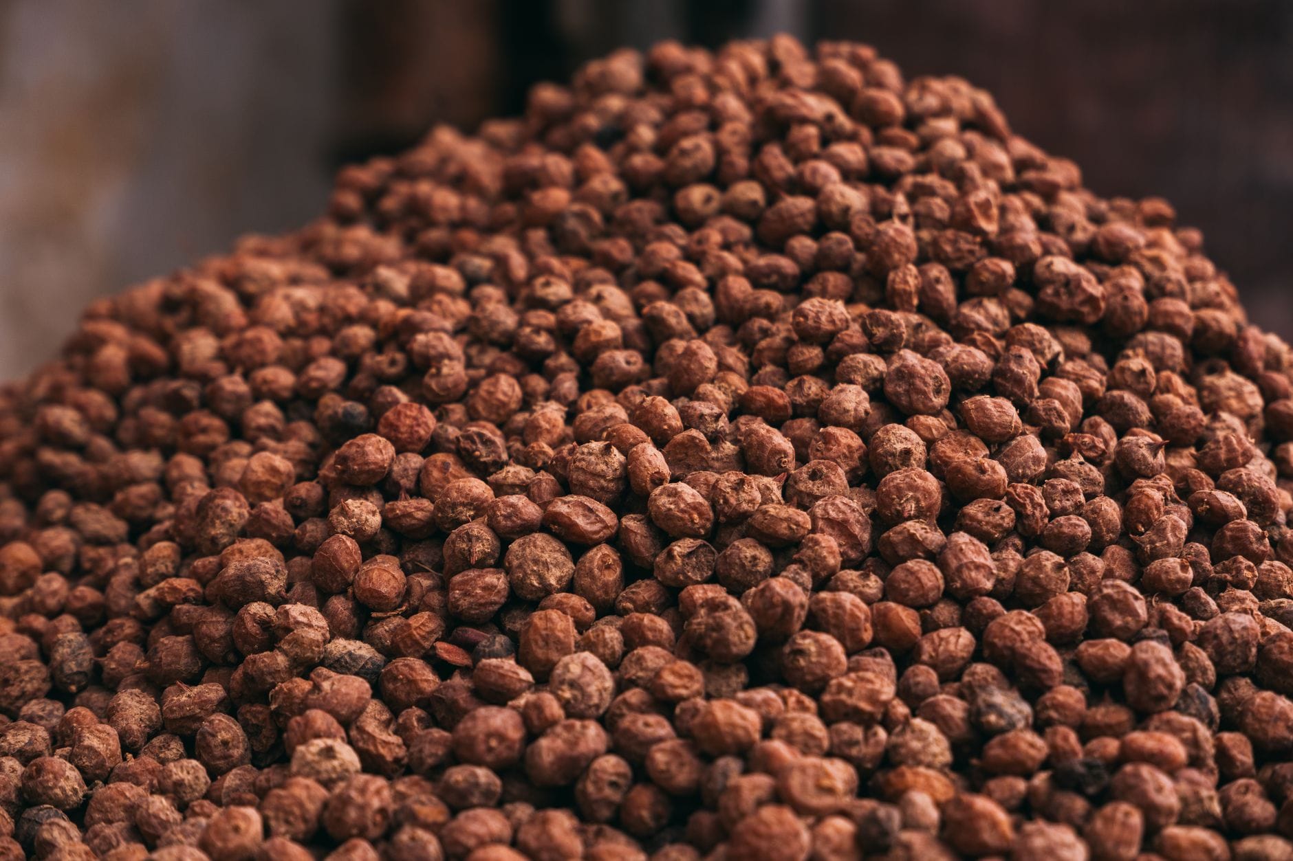 Large pile of dried, wrinkled brown tiger nuts at a market