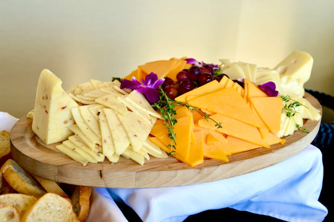 Board of sliced cheeses with grapes, fresh thyme and bread