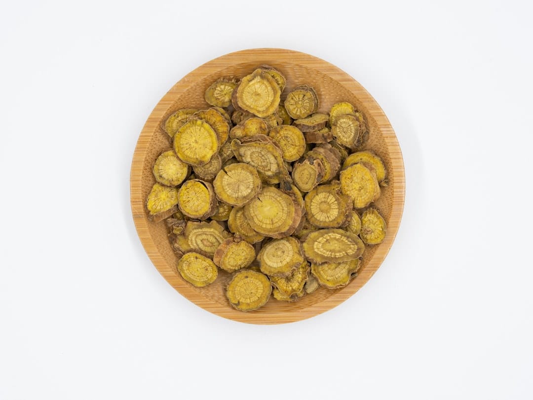 Dried yellow root slices with visible growth rings in a round bamboo dish